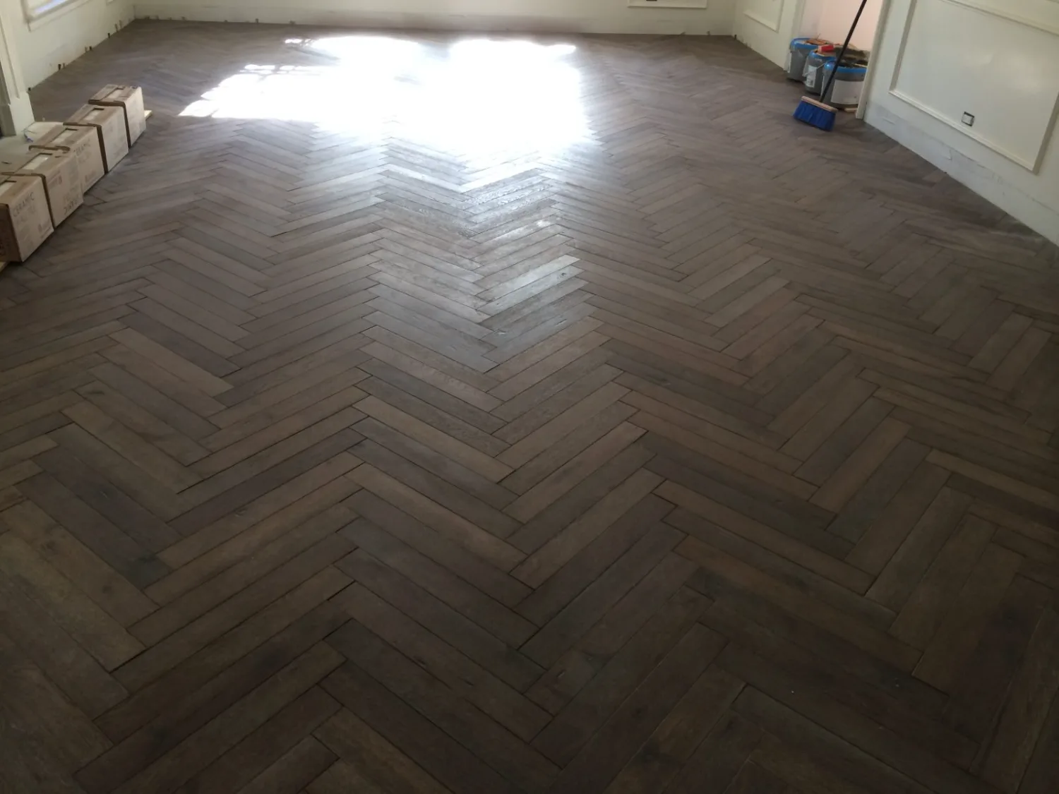 Finished dark herringbone hardwood flooring in a room