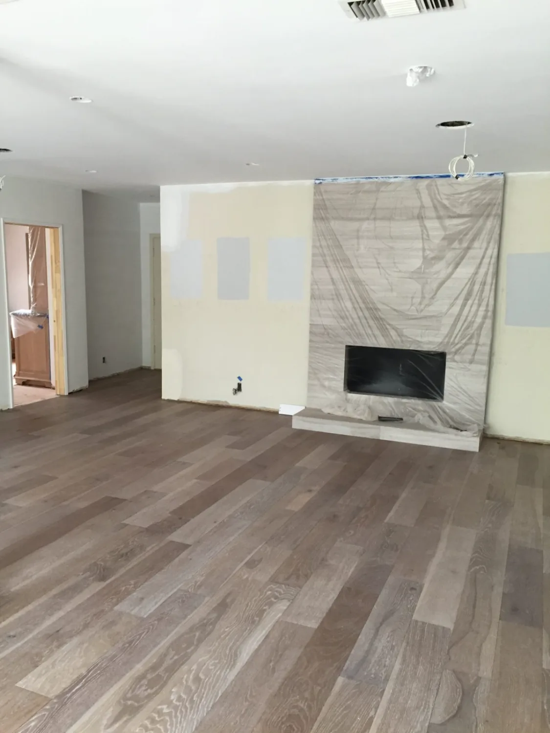 Gray oak hardwood flooring by a fireplace