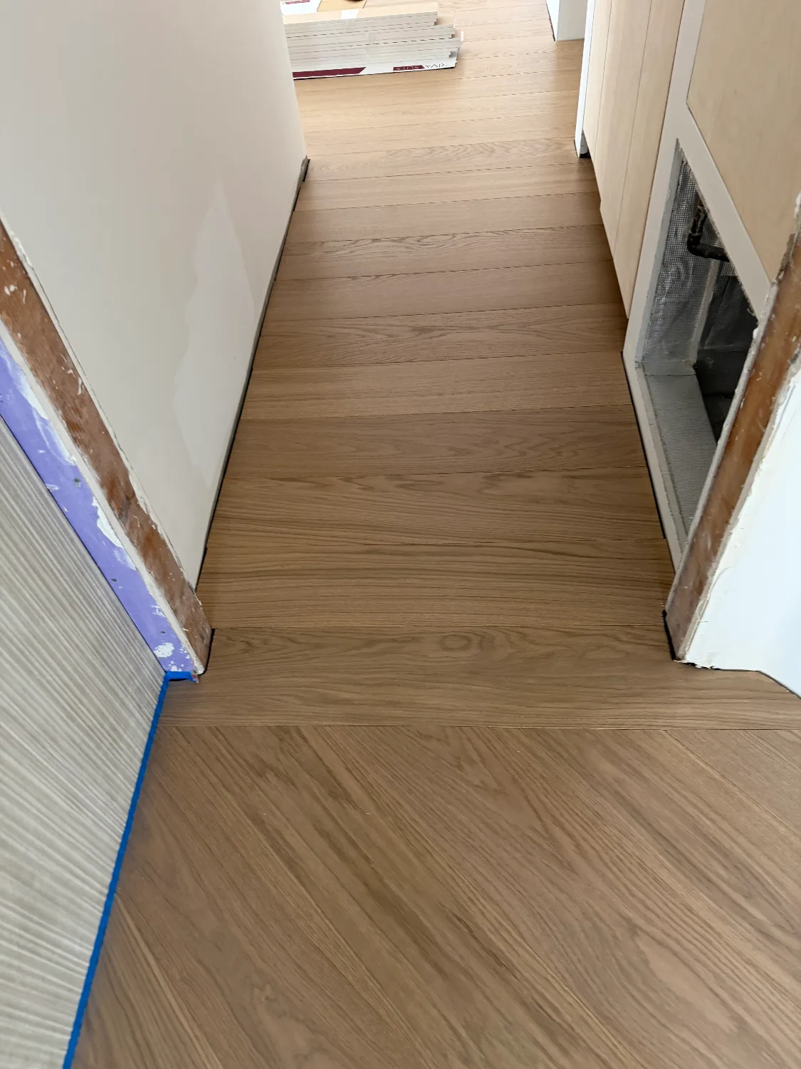 Riva Spain Smoke engineered hardwood floor meeting a tile transition in a hallway