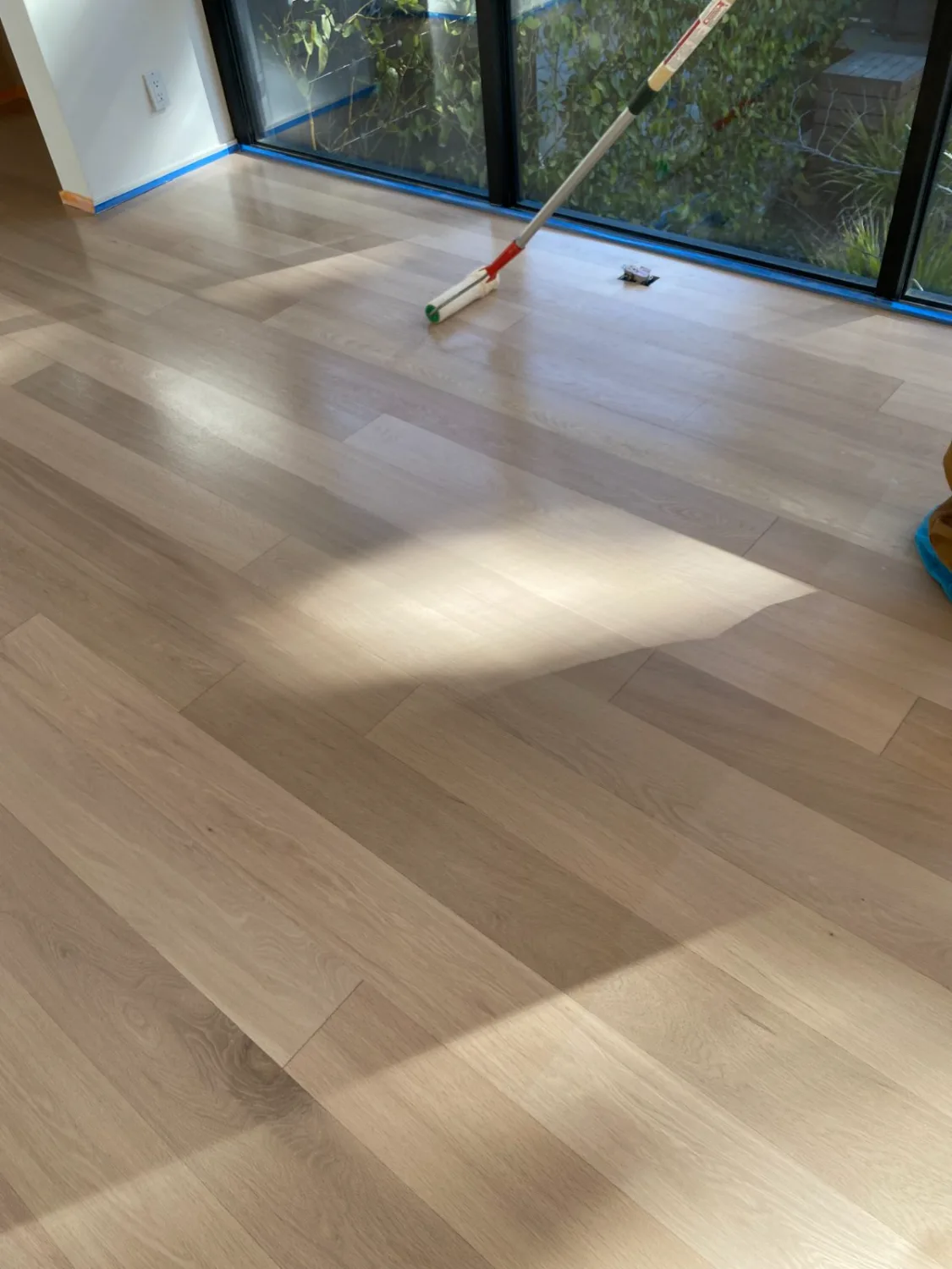 Applying a finish coat to white oak hardwood flooring
