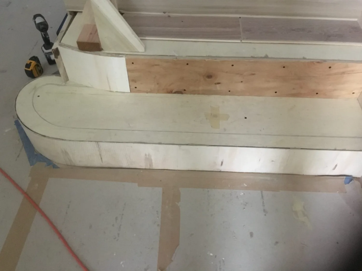 Curved hardwood stair base during installation