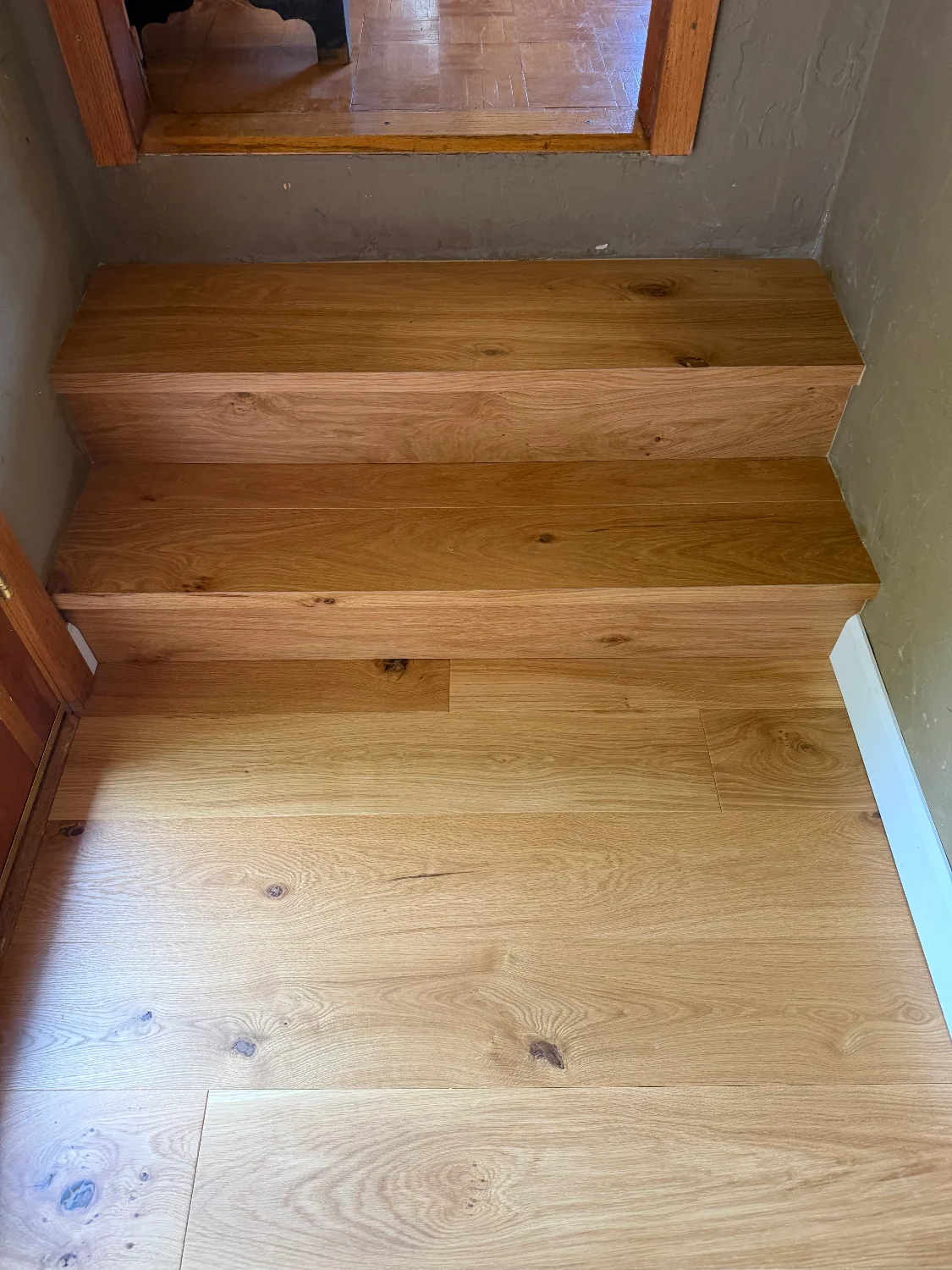 French oak hardwood stair treads with an oil finish above a tile floor
