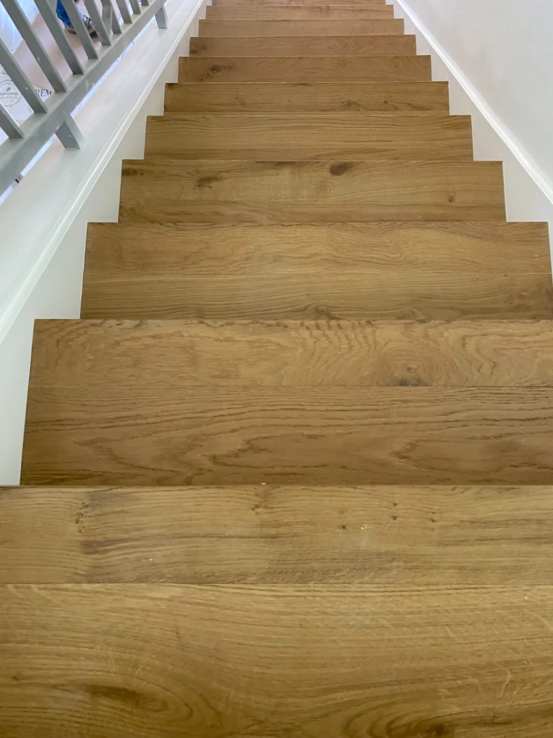Honey-toned oak hardwood stair treads in a straight flight