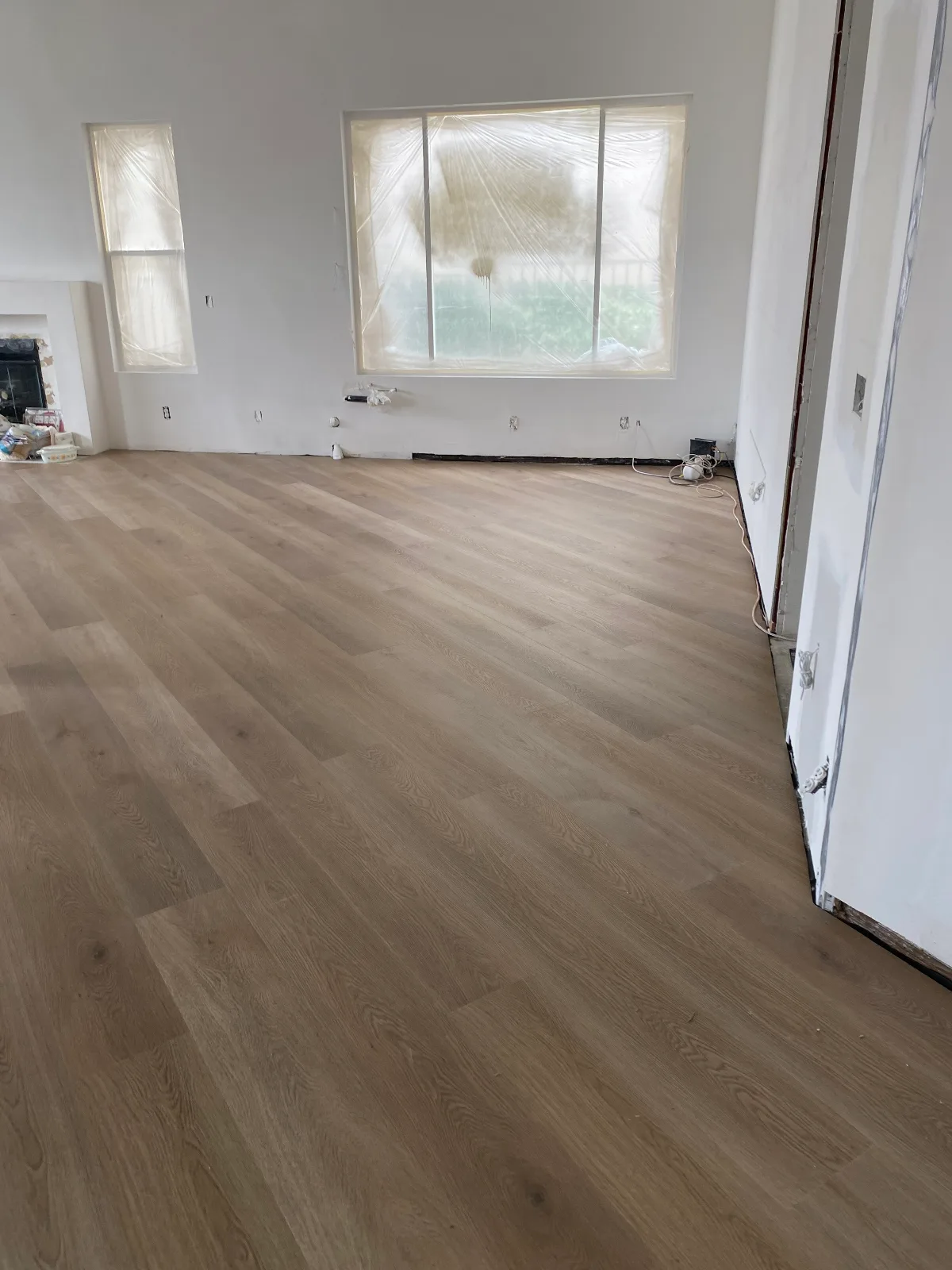 Wide-plank flooring going down over a prepared subfloor during installation