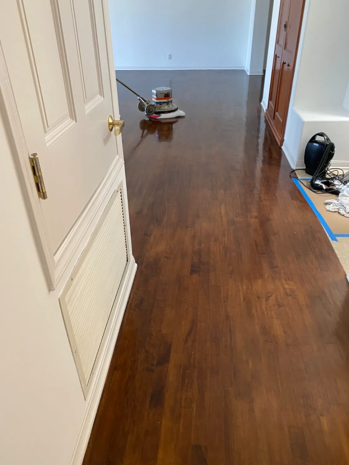 Dark mahogany-toned hardwood floor after refinishing by a doorway